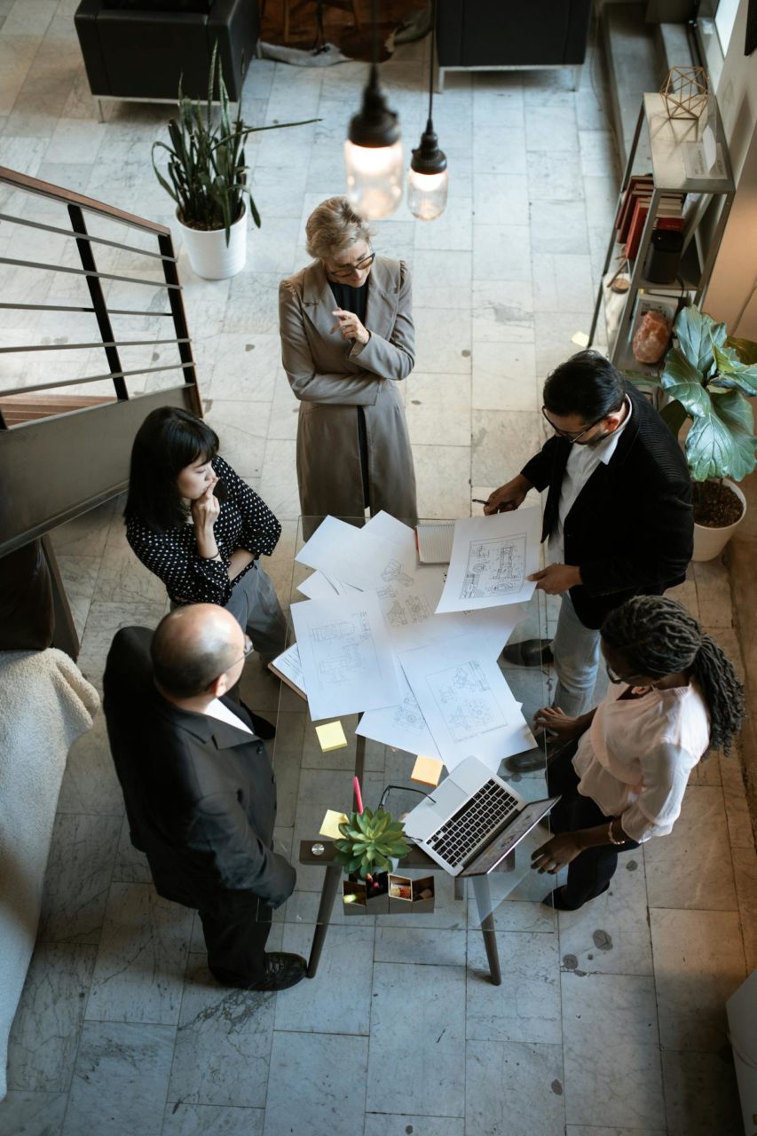 A team of professionals engage in a business meeting in a sleek, modern office setting.