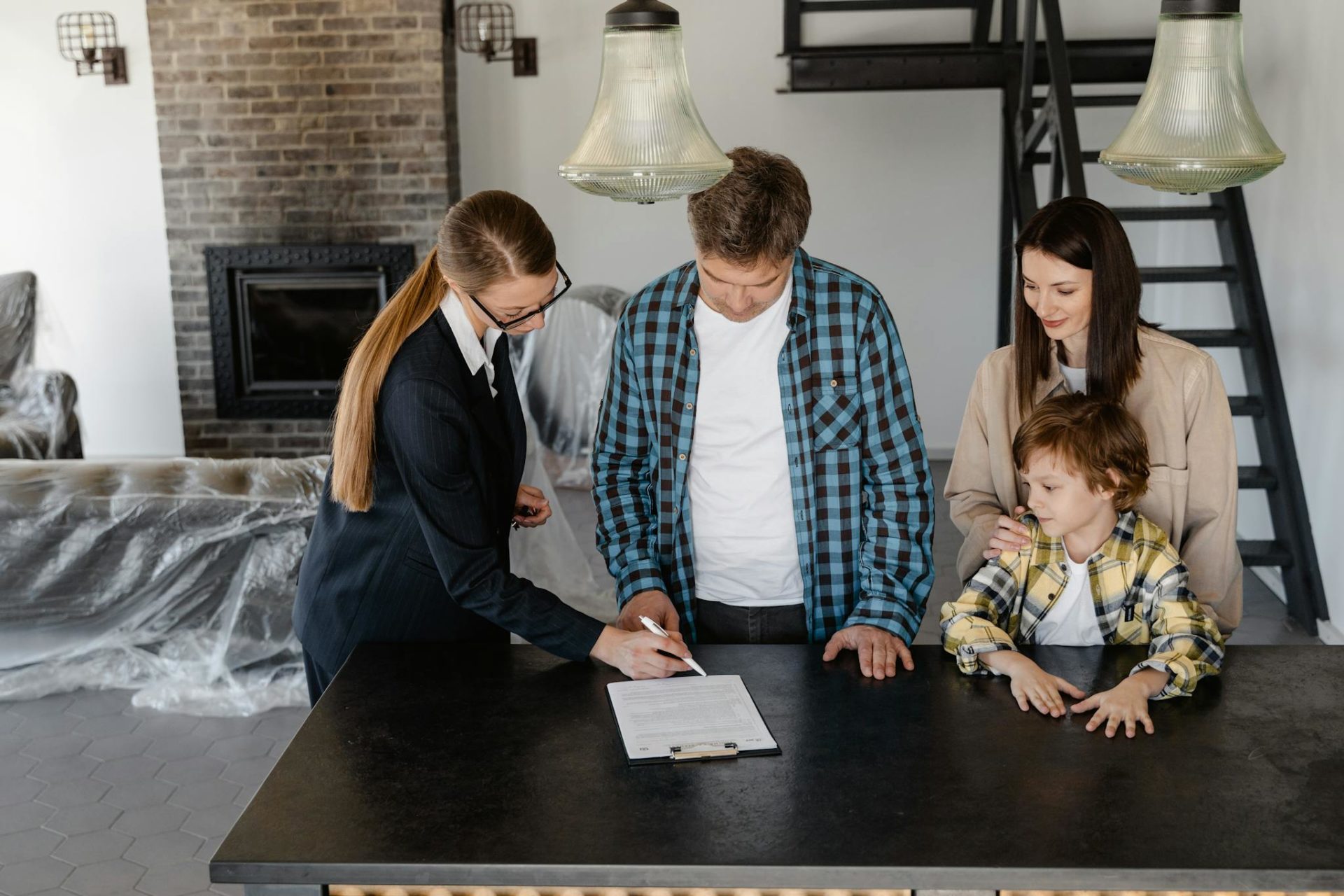 Happy family signing a real estate contract with agent inside their new home.