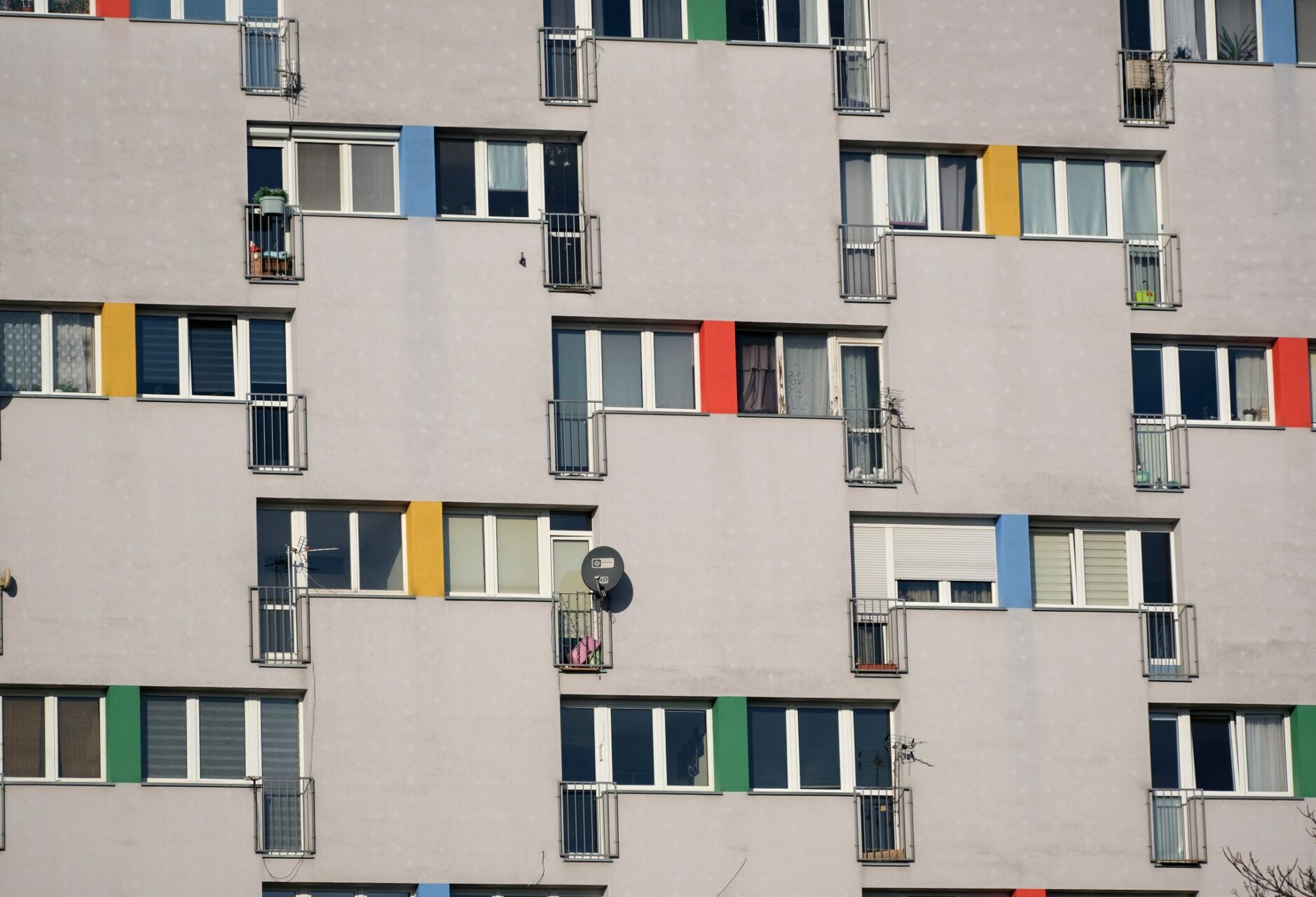Contemporary apartment building facade featuring geometric patterns and vibrant color accents.